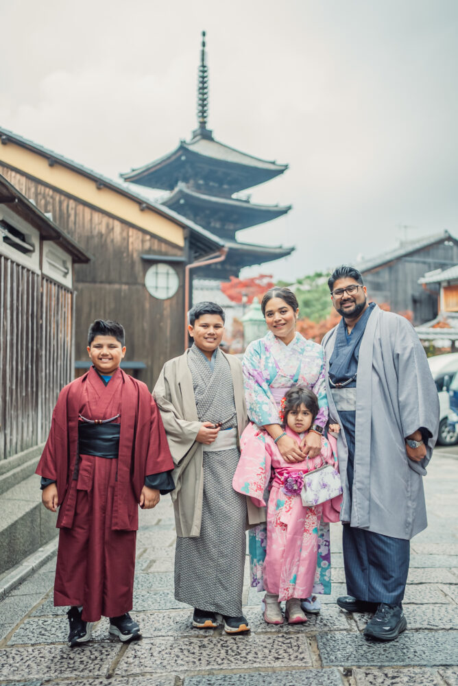A family taking photos in front of Yasaka Pagoda during a Kyoto family photoshoot in Higashiyama