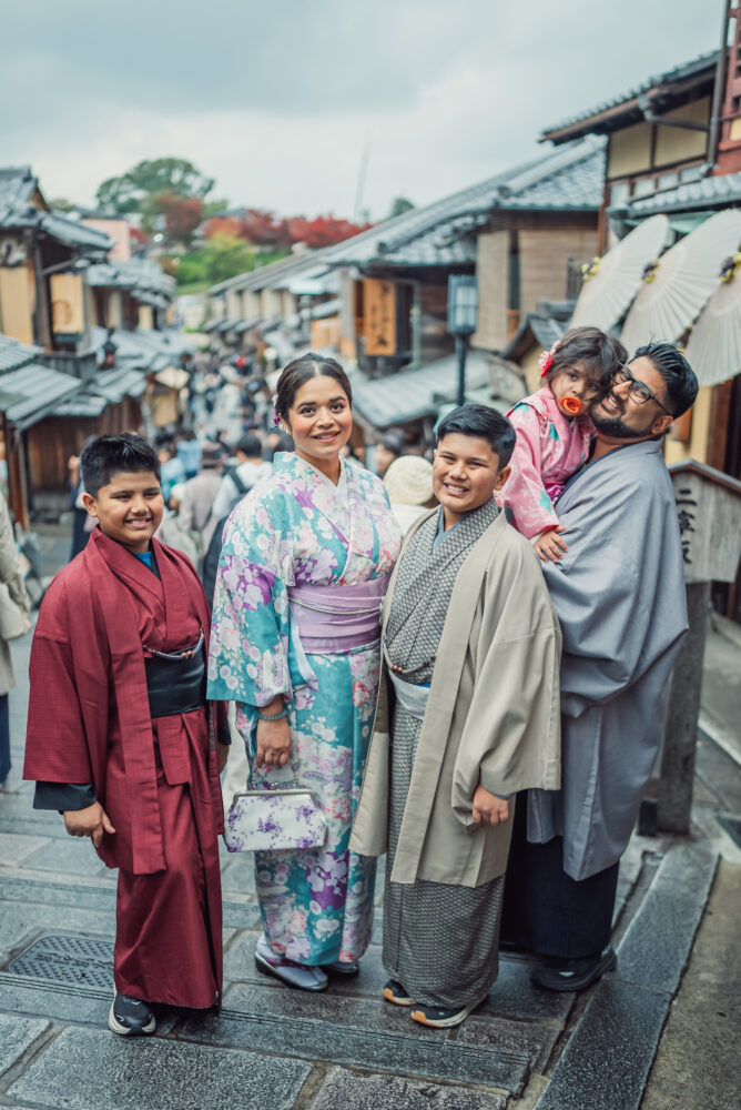 A family taking photos in the traditional Ninen-zaka streets during a Kyoto family photoshoot in Higashiyama