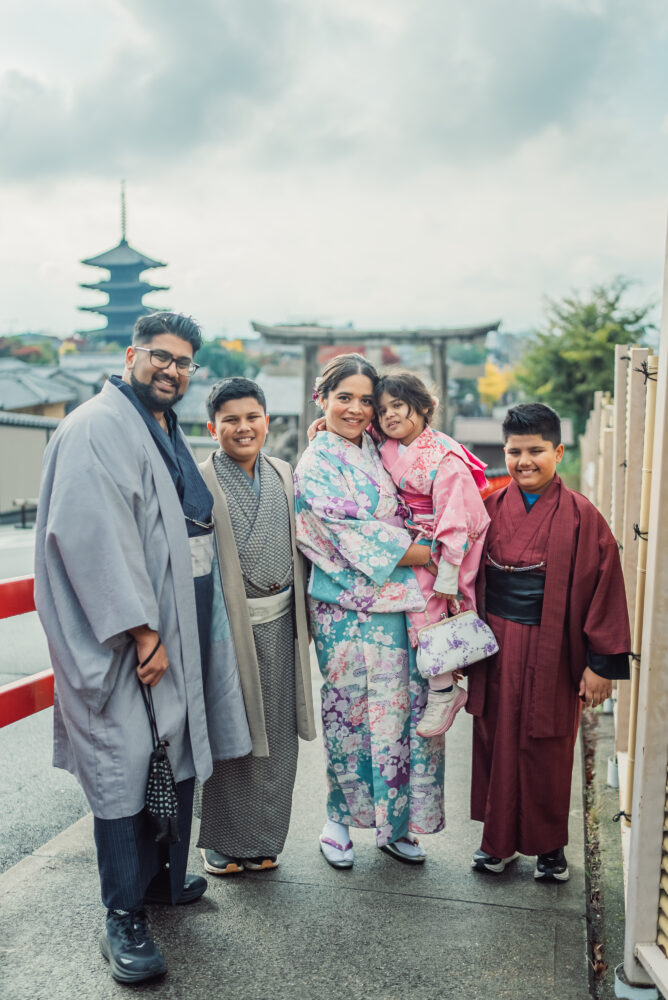 A family taking photos in front of Yasaka Pagoda during a Kyoto family photoshoot in Higashiyama