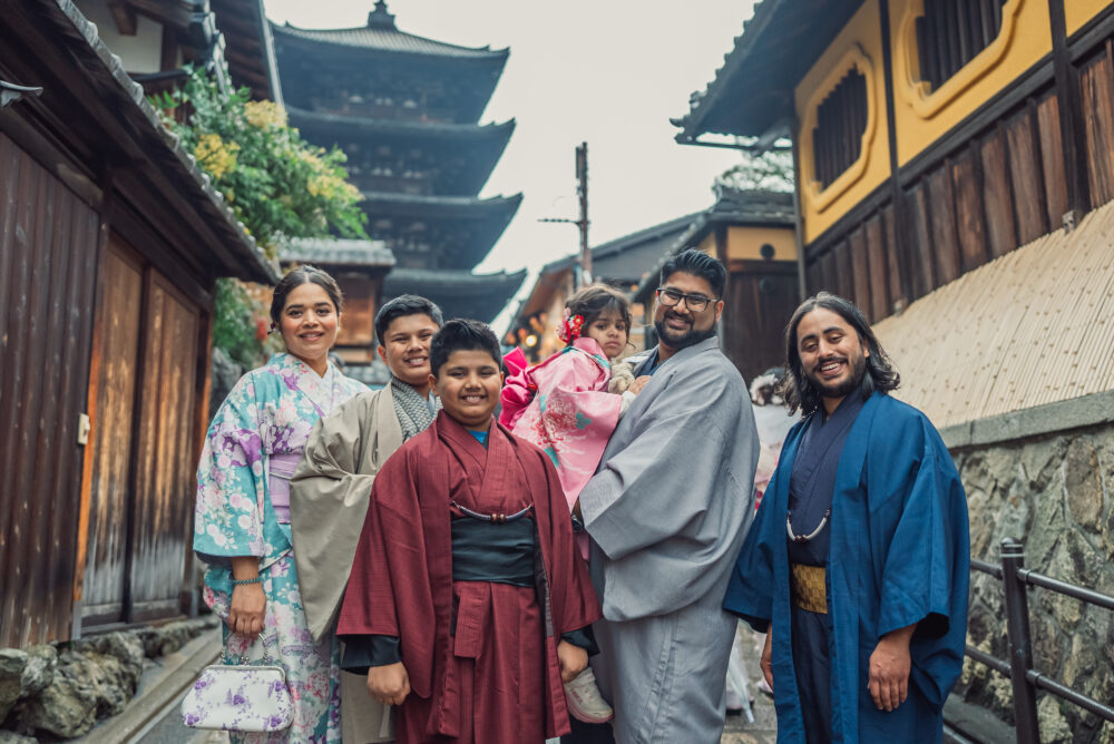 A family posing together with the historic Yasaka Pagoda in the background during their Kyoto travel photography session