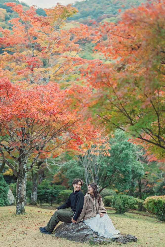 Natural engagement portrait of a couple surrounded by brilliant autumn leaves in Arashiyama Kyoto