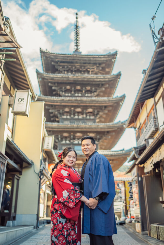 A couple capturing a romantic travel memory in front of Yasaka Pagoda in the historic Higashiyama district of Kyoto