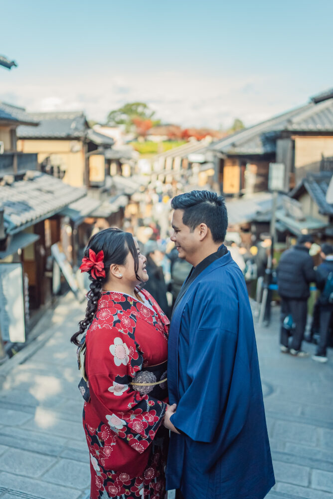 A couple wearing kimono taking photos in the historic Ninen-zaka streets during a Kyoto couple photoshoot