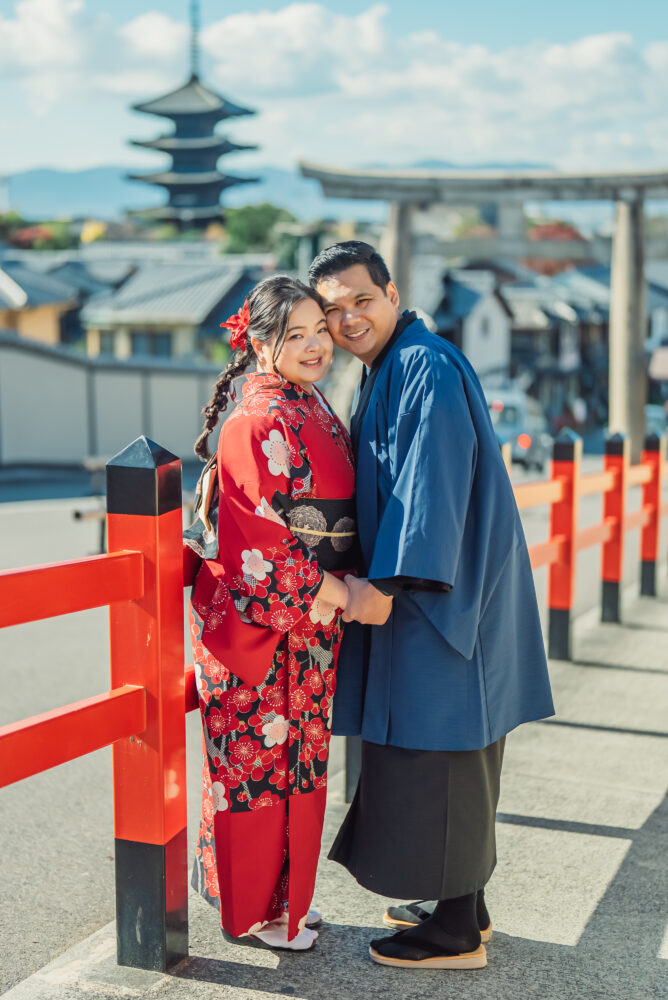 A couple smiling together in front of Yasaka Pagoda during a romantic Kyoto kimono photoshoot
