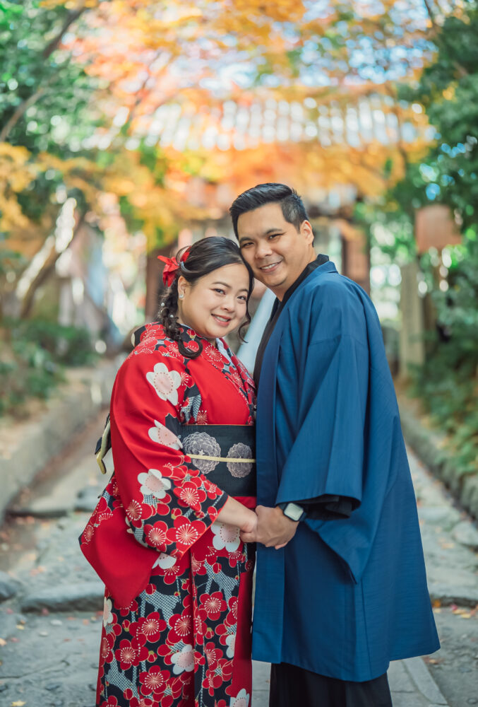 A couple enjoying a romantic moment surrounded by bamboo and beautiful autumn leaves in Kyoto