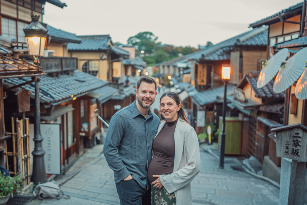 Couple walking through Ninen-zaka historic street in Higashiyama Kyoto during an autumn maternity photoshoot