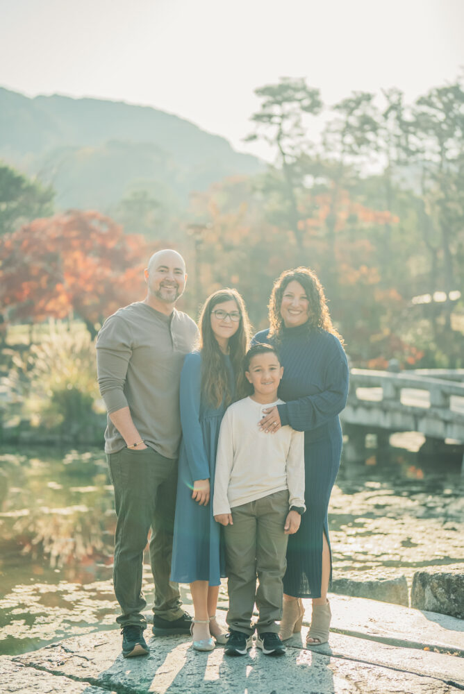 A family surrounded by soft morning light and beautiful autumn leaves during a family photoshoot in Kyoto