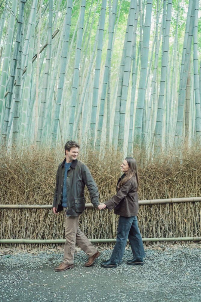 Couple walking through Arashiyama Bamboo Forest in Kyoto during a romantic photoshoot