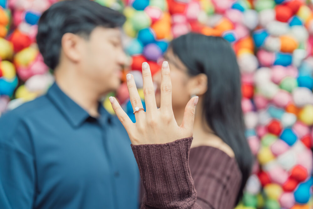 Couple standing near the colorful kukurizaru charms at Yasaka Koshindo Temple in Kyoto Japan