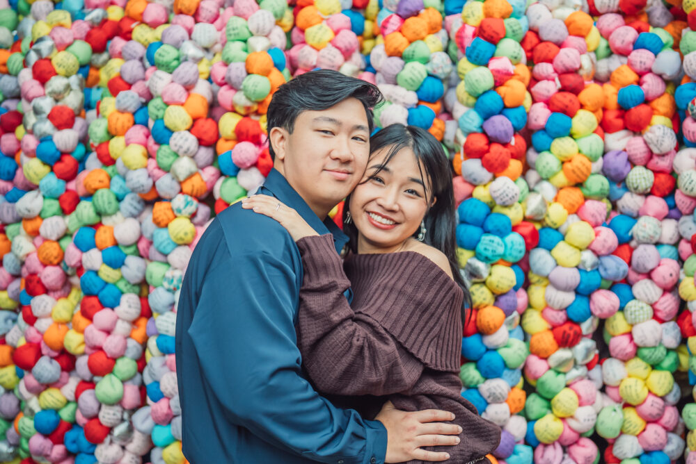 Couple enjoying a romantic photoshoot at Yasaka Koshindo Temple in Higashiyama Kyoto with colorful kukurizaru charms