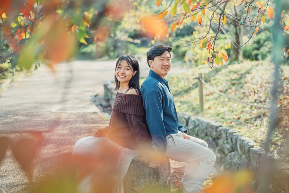 Happy couple sitting together on a bench after a romantic proposal photoshoot in Kyoto