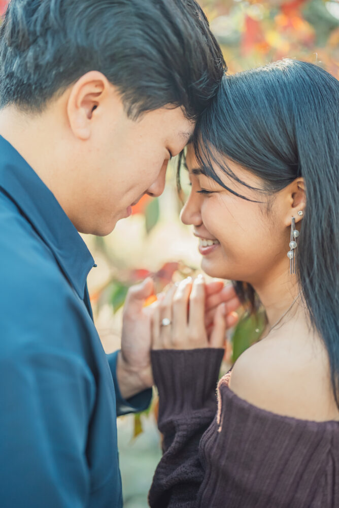 Engaged couple sitting together on a bench surrounded by nature at Maruyama Park Kyoto after their proposal
