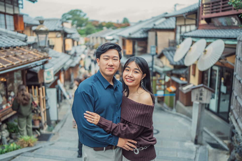 Romantic couple walking through Ninenzaka in Higashiyama Kyoto during an autumn proposal photoshoot