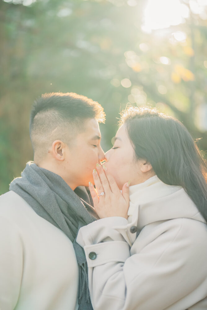 A romantic couple surrounded by soft morning light and beautiful autumn leaves during a Kyoto photoshoot