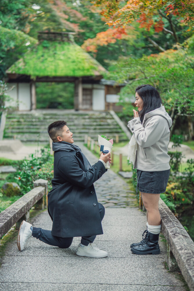 A woman surprised by a marriage proposal in Kyoto with an emotional reaction captured during an engagement photoshoot