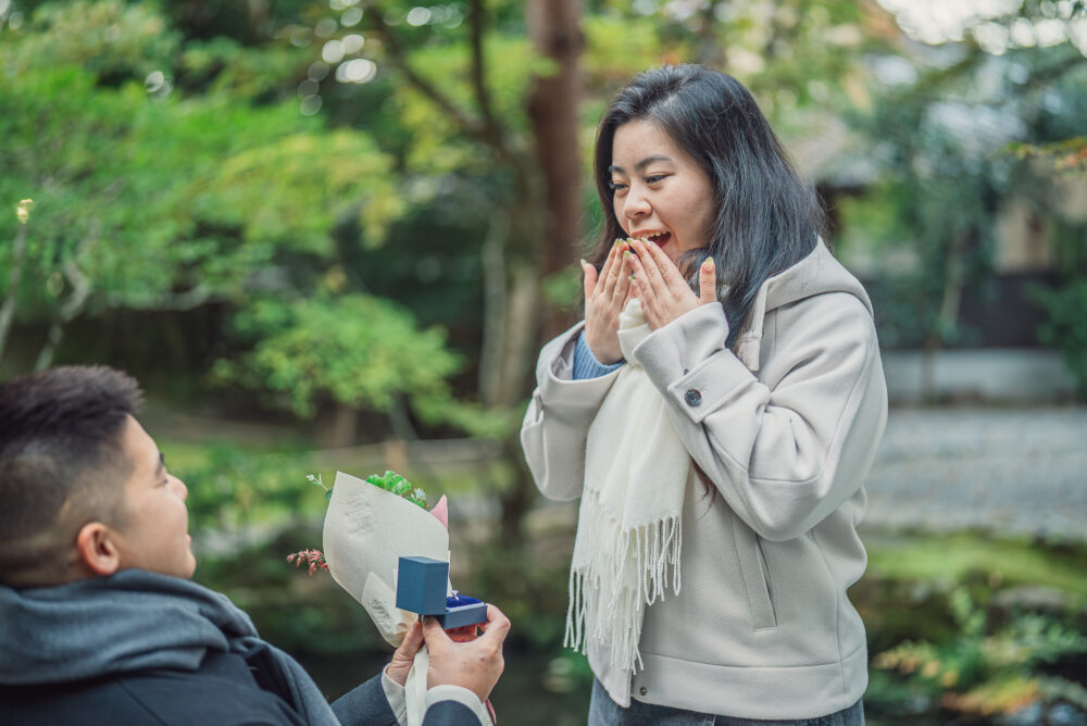 A woman reacting with surprise and happiness during a romantic proposal moment in Kyoto captured by a professional photographer