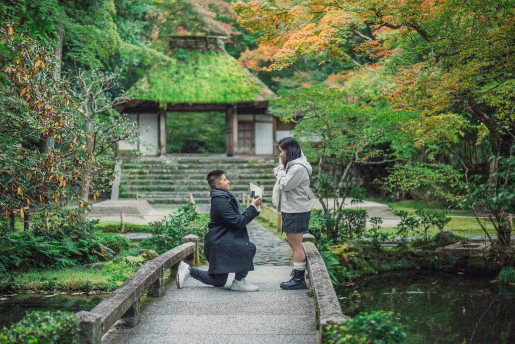 A couple sharing a romantic proposal moment in Kyoto surrounded by beautiful autumn leaves and colorful seasonal scenery