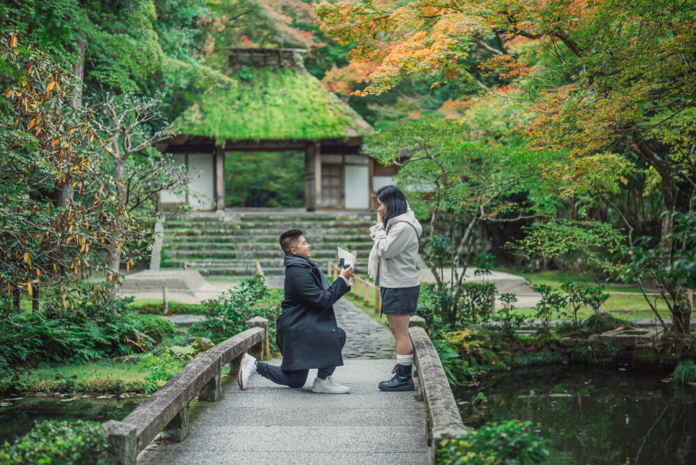 A couple sharing a romantic proposal moment in Kyoto surrounded by beautiful autumn leaves and colorful seasonal scenery