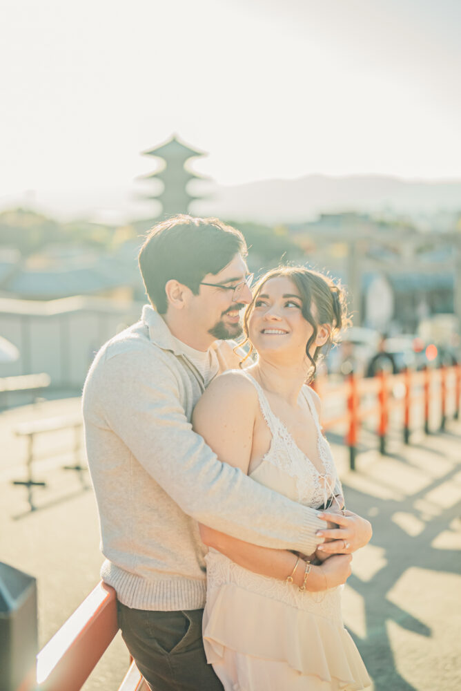 A romantic couple embracing at sunset with Yasaka Pagoda in Higashiyama Kyoto in the background and warm evening light surrounding them
