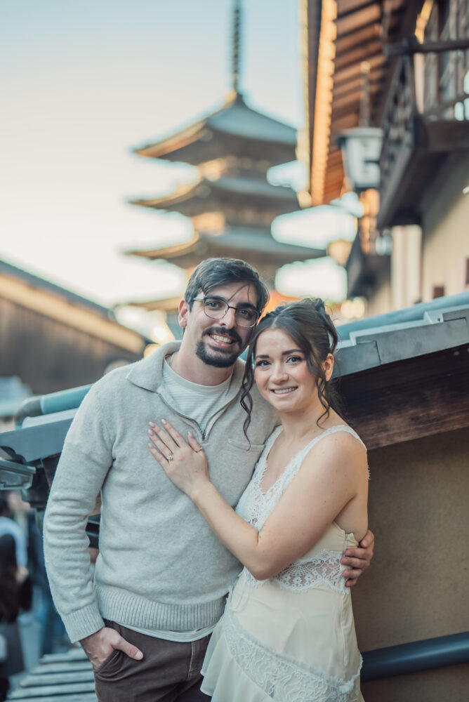 Natural couple photography in Kyoto capturing a happy moment on Yasaka Pagoda with the iconic traditional streetscape of Higashiyama