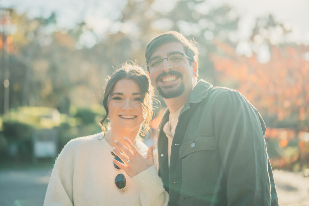 Engaged couple celebrating their proposal on a traditional bridge at Maruyama Park Kyoto with autumn colors and sunset scenery