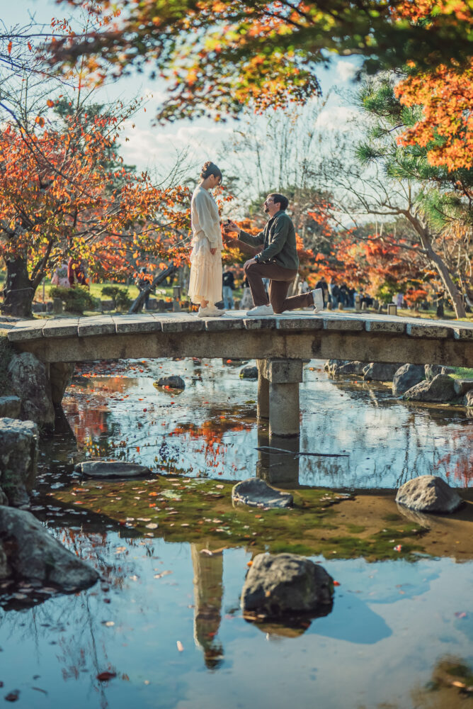 A surprise proposal in Higashiyama Kyoto at Maruyama Park bridge surrounded by autumn leaves and warm sunset light