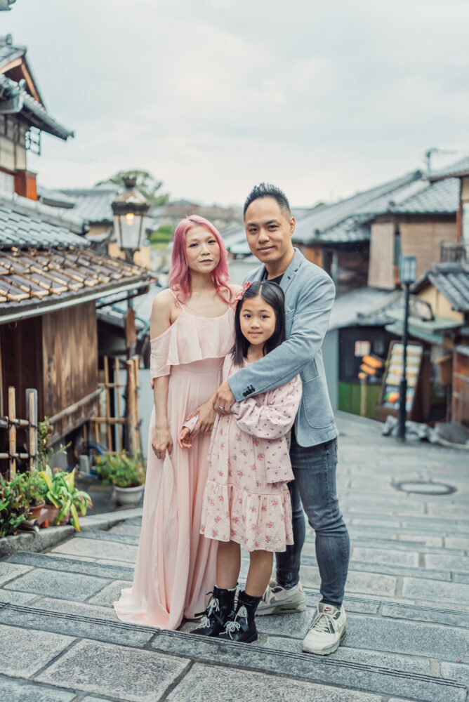 A family hugging naturally on Ninenzaka in Kyoto’s Higashiyama district surrounded by traditional Japanese streets during their Japan trip