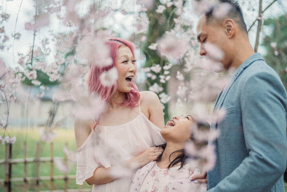 A mother showing a heartfelt expression during a natural family photography session in Kyoto surrounded by beautiful spring scenery